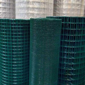 imagem mostrando rolos de tela soldada revestida em pvc verde escuro alinhados na posição vertical no estoque