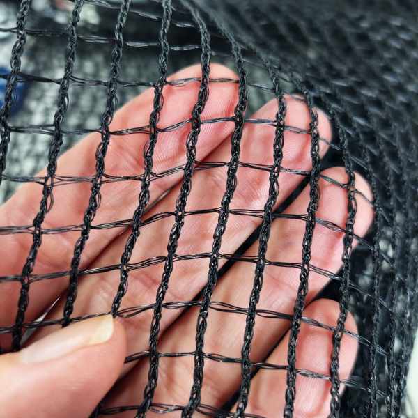 imagem mostrando uma mão humana segurando a tela antipassaro reforçada vista de perto