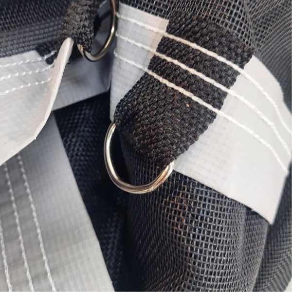 Detalhe das argolas metálicas e reforços da tela de proteção para piscina, desenvolvida para alta resistência e longa vida útil.